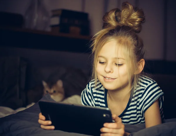 Gyönyörű szőke lány, és mosolyogva néz tabletta — Stock Fotó