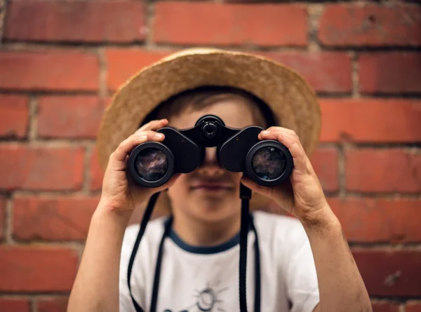 Boy in a straw hat looks in binoculars — Stock Photo, Image