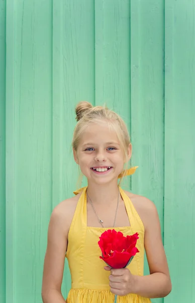 Joven rubia alegre sosteniendo una flor roja — Foto de Stock