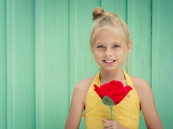 Joven rubia alegre sosteniendo una flor roja — Foto de Stock