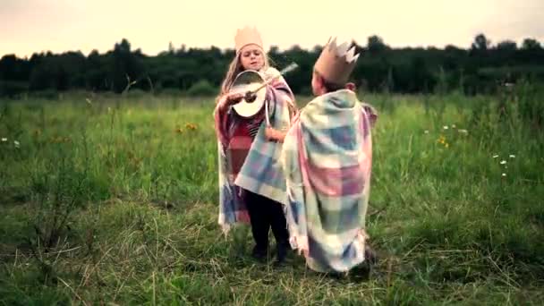 Boy with a girl dressed in knights fighting with swords — Stock Video