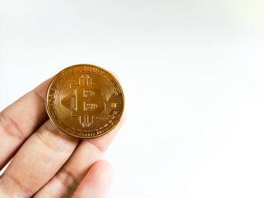 Beyaz arka planda izole edilmiş parlak bir bitcoin 'i tutan el. Kripto para birimi. İnternet bankacılığı ve uluslararası ağ ödemeleri için elektronik sanal para. Seçici odak.