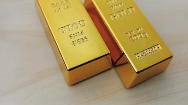 Tahta bir üste dönen iki altın külçesi. Değerli metaller. Altın rezervi altın fiyat yatırımı
