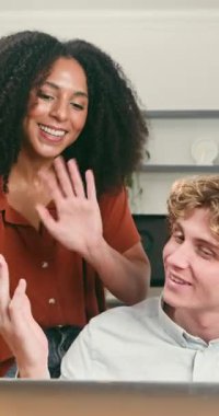 Gülümseyen genç iş adamları modern bir ofiste işbirliği yapıyor ve mutlu bir şekilde iletişim kuruyorlar. Olumlu bir tartışmaya girerler, fikirleri paylaşırlar ve etkili bir şekilde birlikte çalışırlar..