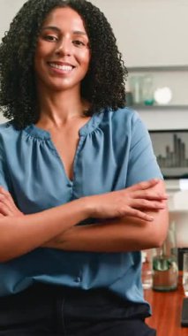 Sıcak bir gülümsemesi olan kendine güvenen profesyonel bir iş kadını modern bir ofiste kollarını kavuşturur. Pozitif tavrı ve liderlik mevcudiyeti, çeşitli iş ve finans temaları için uygun başarı ve kurumsal uzmanlık taşımaktadır..