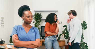 Bir kadın kollarını kavuşturup dinlerken diğerleri dedikodu yapıyor, kabadayılık yapıyor, dışlanıyor, zehirli işyeri