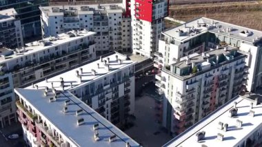 İlginç mimarisi olan modern bir yerleşim tesisinin yörüngesinde yavaşça dönen hava görüntüleri. Güneş ışığı ön cephede güçlü gölgeler oluşturur.