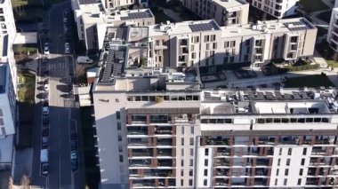 Yüksek açılı manzara çatılarında güneş panelleri olan çağdaş bir apartman kompleksini gösteriyor. Modern bir şehirde kentsel gelişim ve yeşil enerji