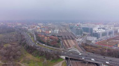 Sisli bir günde Milan 'ın kentsel manzarasının sinematik hava görüntüleri demiryolu boyunca giden araçları ve trenleri gösteriyor.