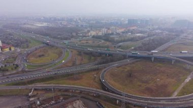 Yüksek irtifa drone görüntüleri sisli bir günde araba ve kamyonlarla büyük bir otoyol kavşağının karmaşık ağını yakalıyor.