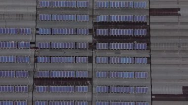 Çok sayıda güneş panelinin yer aldığı endüstriyel çatı katı. Temiz elektrik üreten sürdürülebilir bir enerji kaynağının yukarıdan aşağıya hava görüntüsü