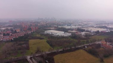 Milan, İtalya 'nın kasvetli panoramik hava manzarası. Endüstriyel ve yerleşim alanlarıyla çevrili modern gökdelenlerle uzak şehir manzarası