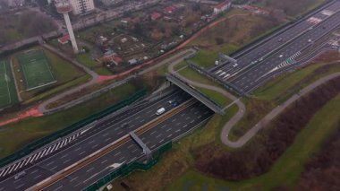 Hayvanlar için çok şeritli bir otoyoldan geçen yeşil bir köprünün hava görüntüleri. Çevre koruma için sürdürülebilir altyapı