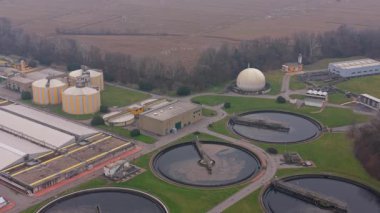 Yukarıdan görülen endüstriyel atık su arıtma tesisi. Büyük yuvarlak tanklarda kanalizasyon ve atık işleme ve yakınlarda bir biyogaz tesisi
