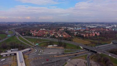 Yüksek açılı insansız hava aracı perspektifi otoyol kavşağından geçen arabaları gösteriyor.