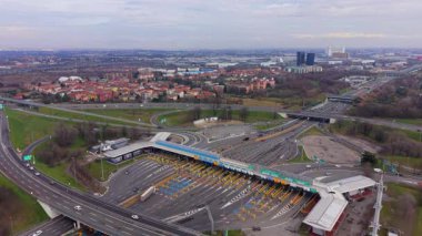 Büyük bir otobandan geçen araçların yüksek irtifa perspektifi. Araba ücretlerini ödeyen ulaşım altyapısı meşgul.