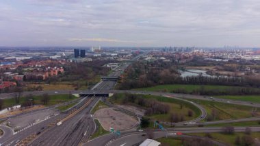 Geniş panoramik otoyol kavşağı manzarası ve bulutlu bir günde Milan, İtalya 'ya doğru giden arabalı gişe gişesi.