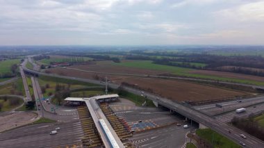 Yüksek açılı insansız hava aracı perspektifi otoyol ve otoyol kavşağından geçen arabalar ve kamyonlar.