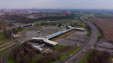 Geniş hava perspektifi, büyük bir otoyoldaki büyük bir gişeden geçen araç trafiğini gösteriyor.