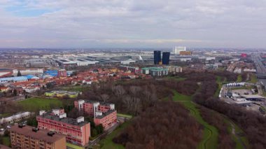 Bulutlu bir günde Parco del Fanciullo ve Rho Fiera Milano sergi merkezinin hava manzarası. İnsansız hava aracı şehir arazisinin üzerinde uçuyor.