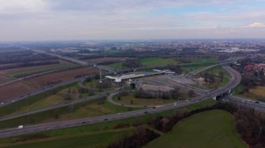 Karmaşık bir otoyol kavşağından geçen otomobil ve kamyonlar gişeden geçiyor. Ulaşım altyapısı ve trafik akışının hava görüntüsü