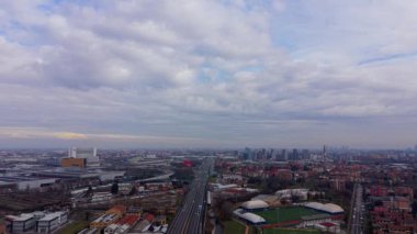 Milan, İtalya 'ya giden yolu gösteren çarpıcı hava görüntüleri. Kamera, şehir manzarasını ve modern gökyüzünü gözler önüne seriyor.