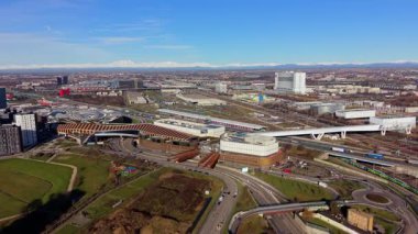 Turin, İtalya, şehir manzarası modern mimari, yoğun otoyol trafiği ve karla kaplı Alp Dağları 'nın geniş hava manzarası.