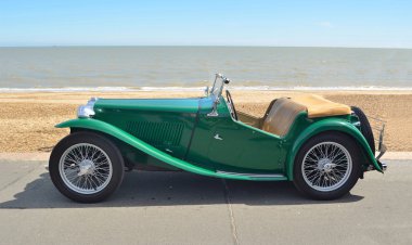  Classic Green MG Sports car parked on seafront promenade. clipart