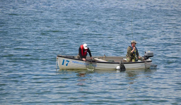 Deux pêcheurs pêchant avec des cannes en bateau . — Photo