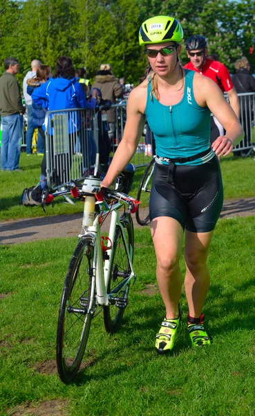 Triatleta feminina no final da etapa de ciclismo com bicicleta . — Fotografia de Stock