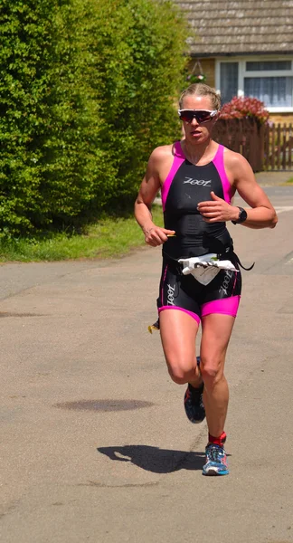 Female triathlete on running stage of triathlon. — Stock Photo, Image