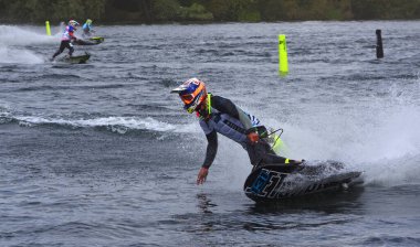Erkek Motorsörf Yarışmacısı arka plandaki diğer yarışçıların hızıyla hareket ediyor.