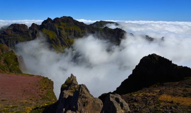  Pico do Areeiro Madeira tepeleri üzerinde mavi gökyüzü olan bulutların arasında.