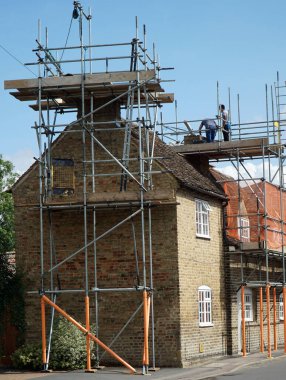 St. NEOTS, CAMBRIDGESHIRE, İngiltere - 09 AĞUSTOS 2021: Kır evi iskeleli bacaları onarıyor.