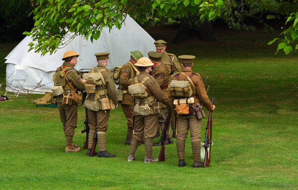 SILSOE, BEDFORDSHIRE, ENGLAND - AUGUST 14, 2021: Men in World War One uniforms  with rifles in camp.