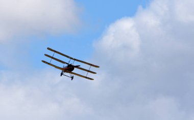 Klasik Sopwith Triplane uçuşu mavi gökyüzü ve bulutlar önden görünüyor