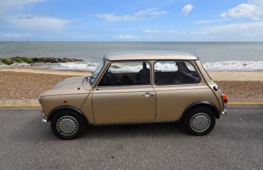 Felixstowe, Suffolk, İngiltere - 04 Mayıs 2025: Arka planda deniz kenarında park edilmiş klasik Austin Mini Car.