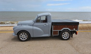 Felixstowe, Suffolk, İngiltere - 04 Mayıs 2025: Arka planda deniz ve deniz manzaralı deniz kenarında park etmiş klasik Morris Minor kamyonet.