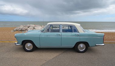 Felixstowe, Suffolk, İngiltere - 04 Mayıs 2025: Klasik Morris Oxford Serisi 5 arka planda deniz kıyısında gezinti sahili ve deniz kenarında park edilmiş.