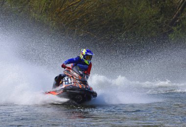 WYBOSTON, BEDFORDSHIRE, ENGLAND - 12 NİSAN 2025: Jet Ski yarışçısı hız konusunda virajda bir sürü sprey yapıyor