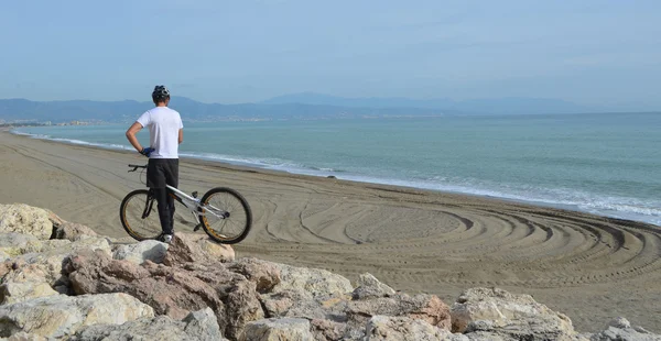 Young Trials Rider with Bike on Rocks Torremolinos Beach Spain.