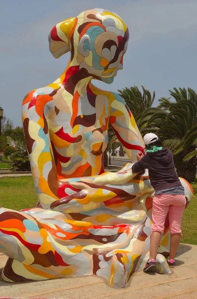 Mujer trabajando pintando colorida estatua en un día soleado . —  Fotos de Stock