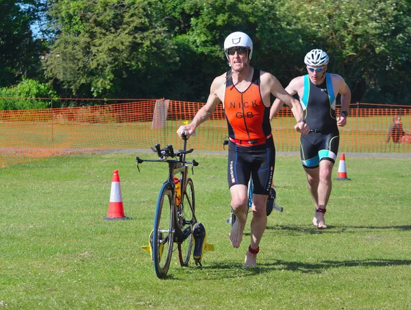 Triathlon Men running in to change over with bikes. — Stock Photo, Image