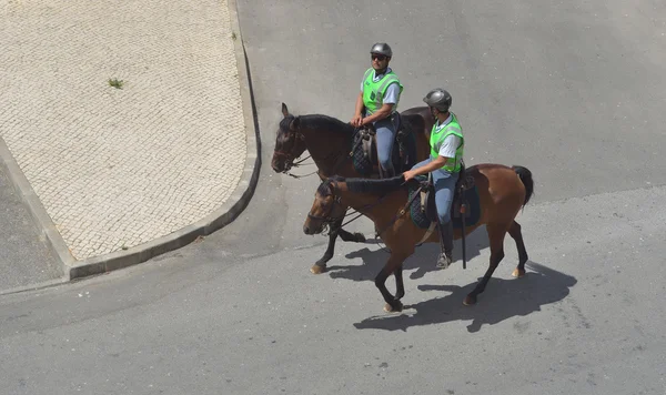 Dois policiais portugueses em cavalos patrulhando ruas . — Fotografia de Stock