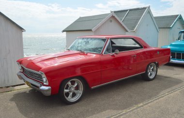 Klasik kırmızı Chevrolet Chevy II motorlusunu Felixstowe sahil üzerinde.