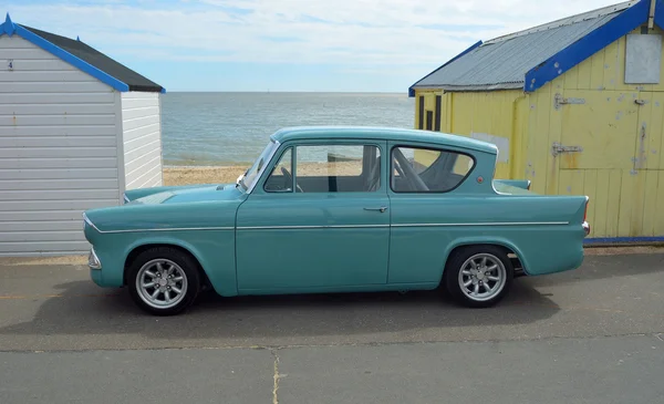 Klasický modrý Ford Anglia o plážové chatky na promenádě Felixstowe. — Stock fotografie