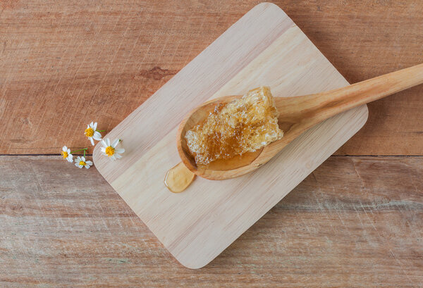 Fresh honey with honeycomb on a wooden chopping board