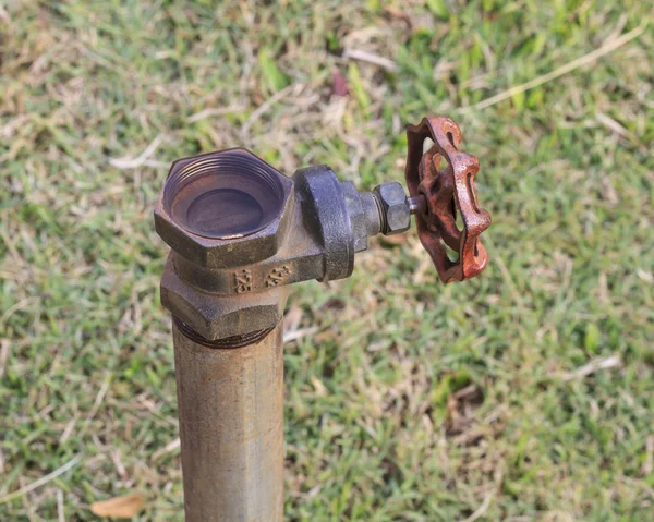 Plumbing valve and metal pipe in garden — Stock Photo, Image