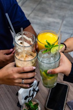 Arkadaşlar bardaki bir partide kadeh tokuşturuyor.