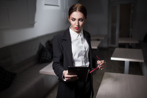 businesswoman in suit and with red lips and with tablet;